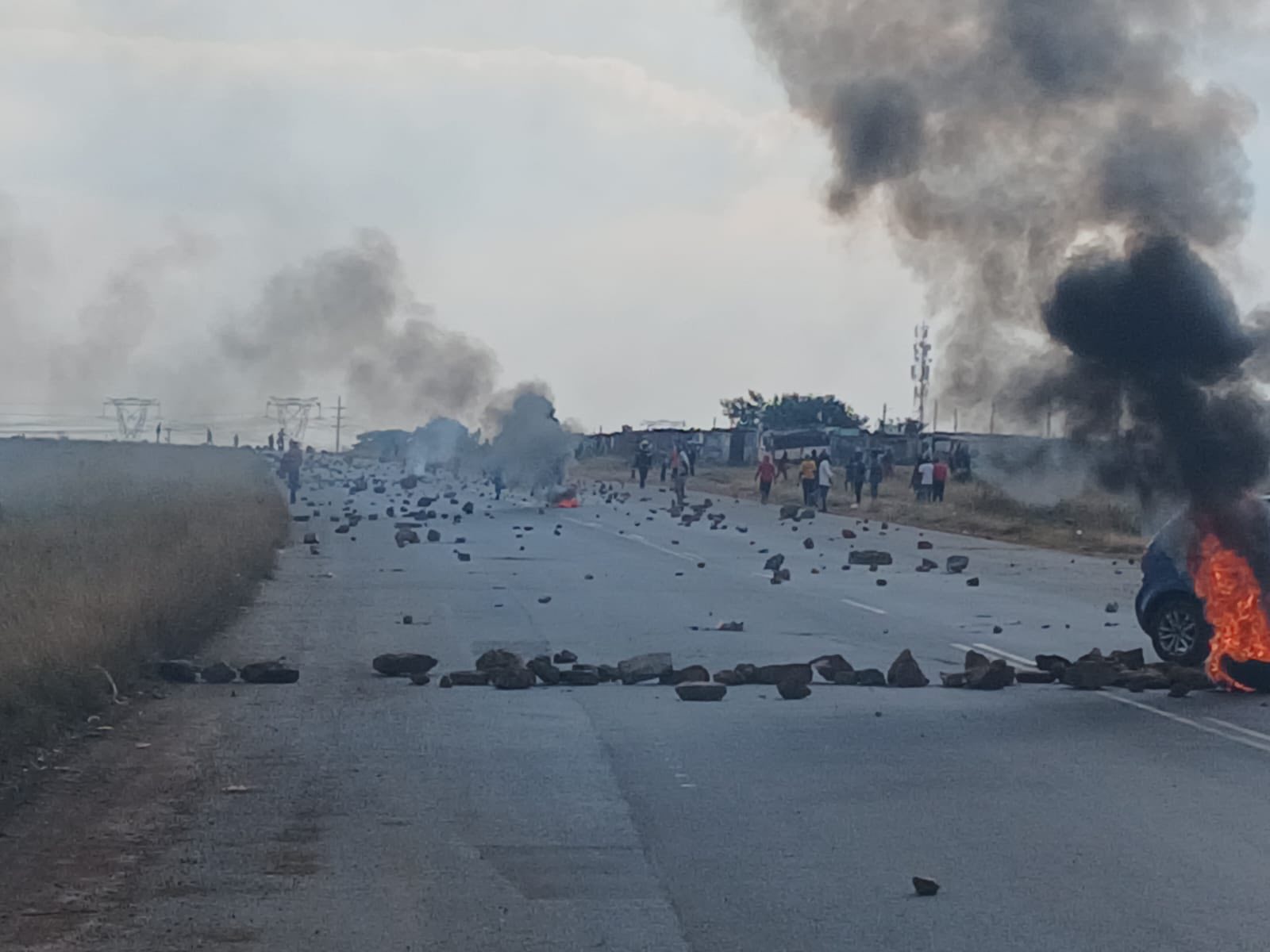 The R550 road is currently barricaded with stones and burning tyres due to protest action in the area